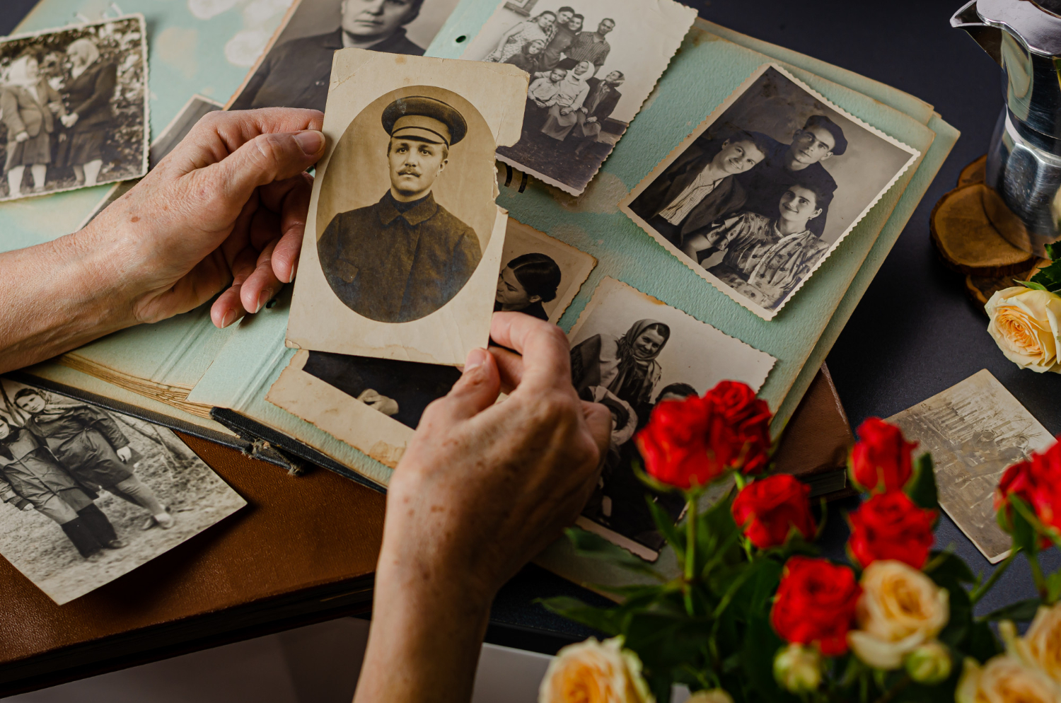 Hands holding an old family photo from a vintage photo album