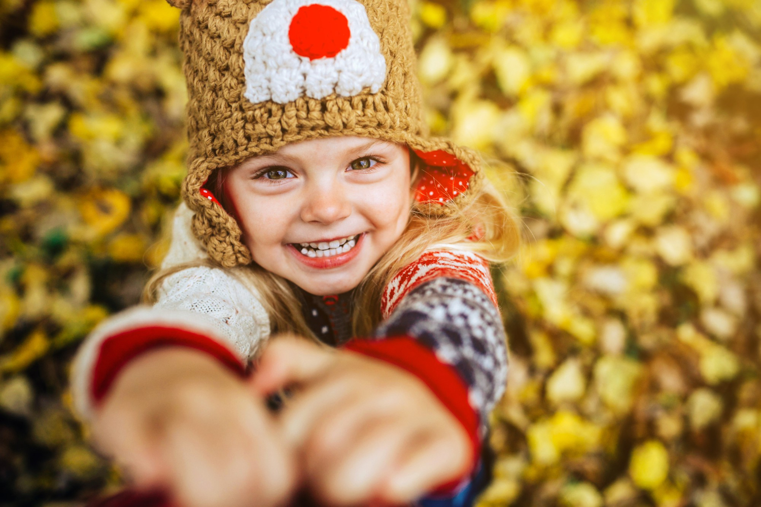 Girl laughing in front of yellow autumn leaves