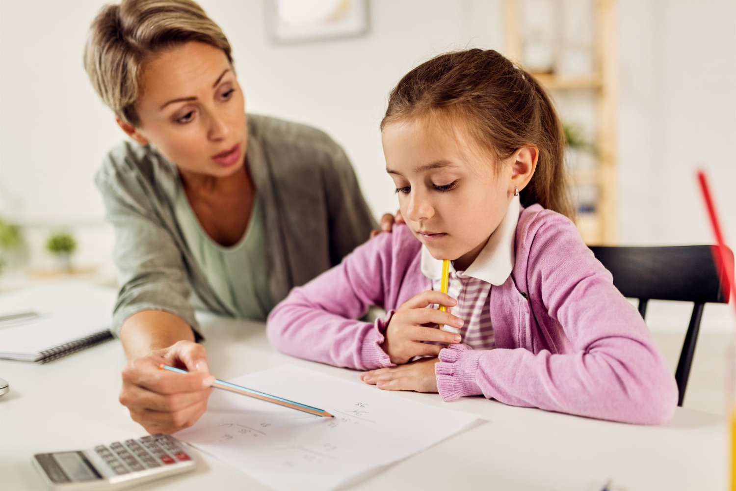 Small girl studying math with her mother at home